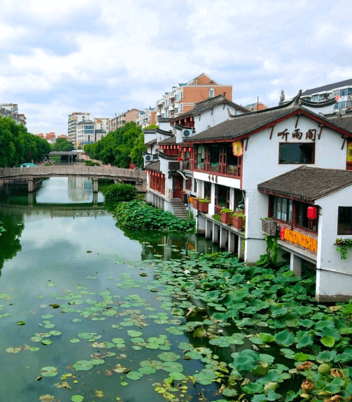 Suzhou canal with bridge and traditional white-walled buildings