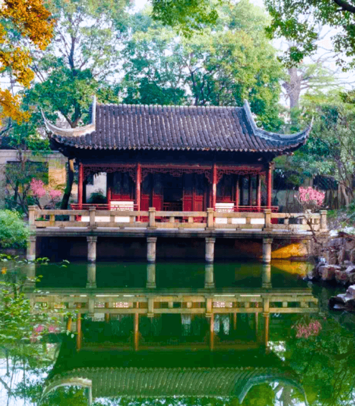 Classical Chinese garden with red pavilion, water features, and serene ambiance