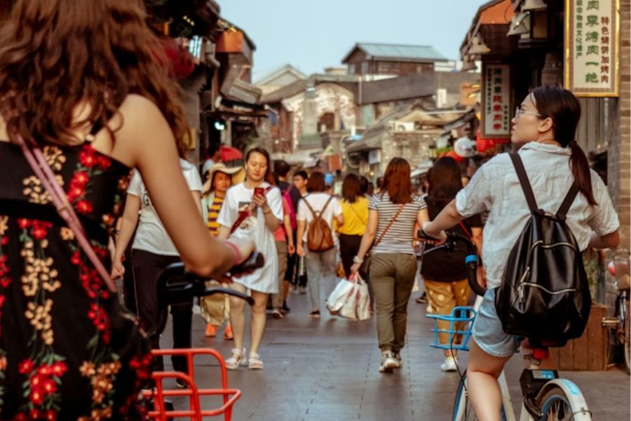 Travelers in hanfu walking down a traditional alley during cultural tour
